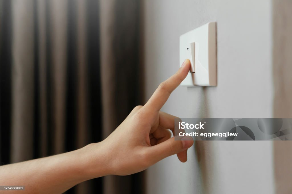 Female finger is turn off on lighting switch Close up of Female finger is turn off on lighting switch at home. Power, Energy, Saving Electrical, Copy space. Lighting Equipment Stock Photo