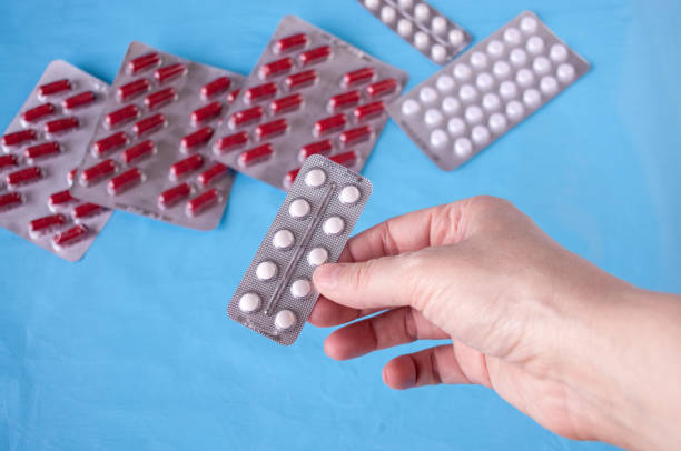istock Hand holding pills on a blue background 1264928508