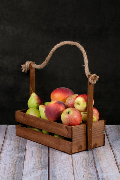 istock Ripe apples, pears and peaches in a wooden box 1264930118