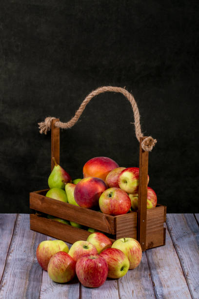 istock Ripe apples, pears and peaches in a wooden box 1264930121