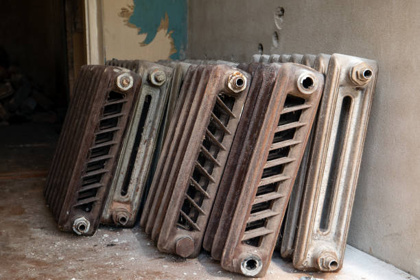 Old cast iron radioators at the wall. Renovation and reconstruction of heating system