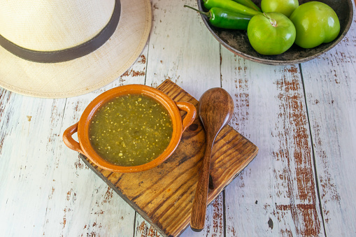 top view of mexican green sauce with tomatillos and serrano pepper and sombrero