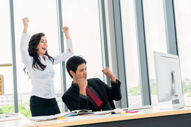 istock Two happy business people celebrate at office 1264933496