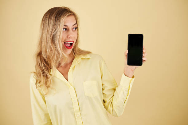 istock Excited woman looking at smartphone 1264933567