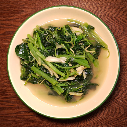 Directly above view a plate of stir fried Chinese spinach