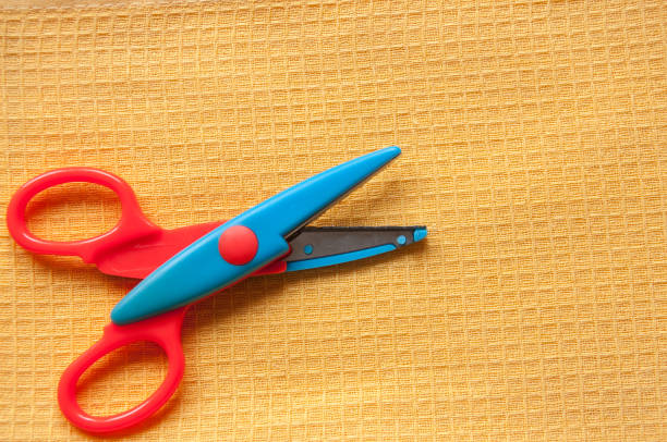 istock The scissors are lying on a yellow linen cloth close up 1264936058