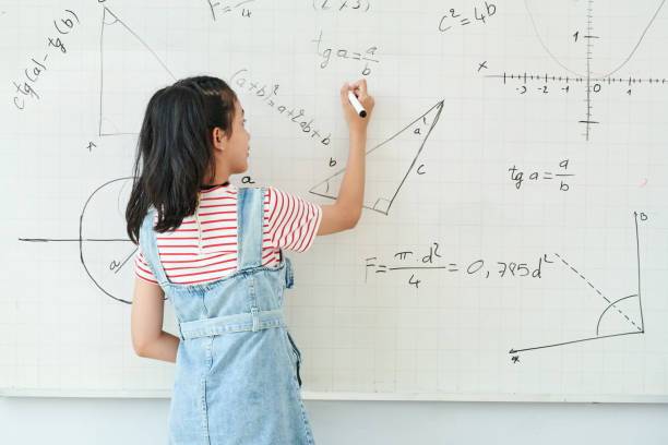 istock Schoolgirl writing on whiteboard 1264944870