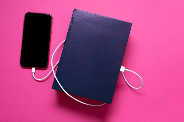 istock Smart phone connected to the old book with a cable, and download information from there 1264946014