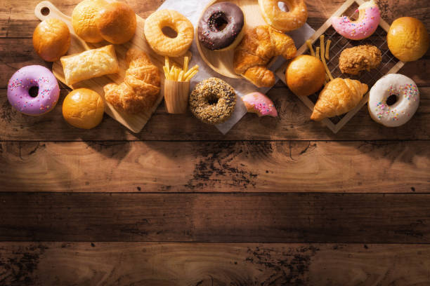 assorted junk food multiple type on wooden table of top view with copy space.
