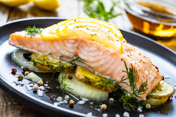 istock Roasted salmon steak served with lemon and onion on wooden table 1264952407