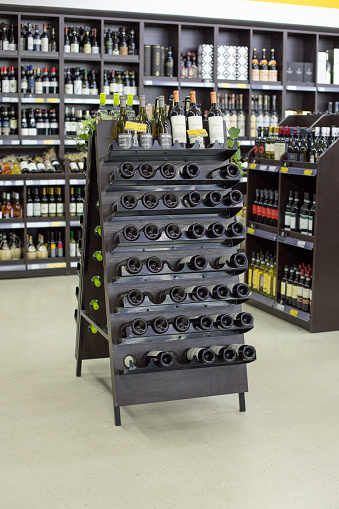 Moscow, Russia - January 6, 2020: Department of alcoholic drinks in a supermarket, wine cellar, beautiful triangular stand for bottles of grape wine. Imported wine products in the assrotiment