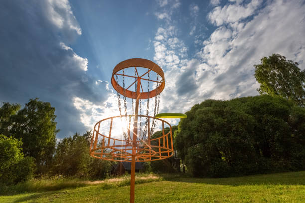 istock Disc golf basket and flying disc in summer park, Finland 1264956173