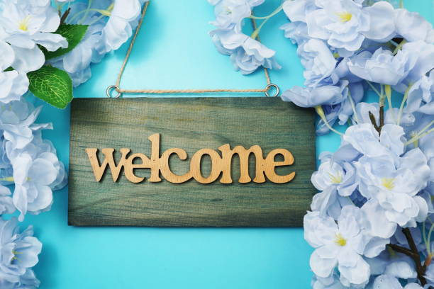 istock Welcome Sign and Flower Blooming Decoration on blue background 1264957403