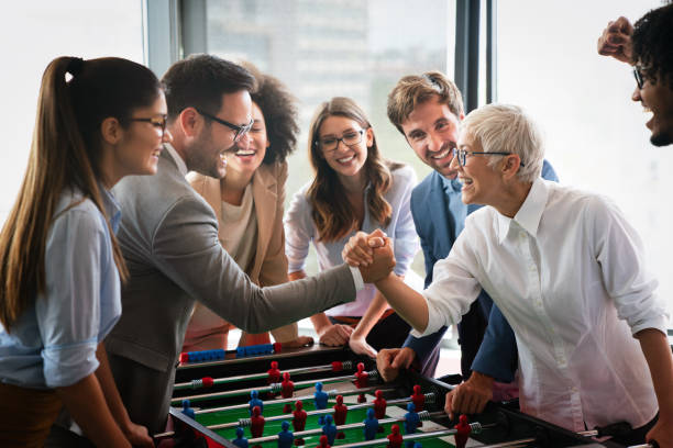 istock Employees playing table soccer indoor game in the office during break time 1264958741