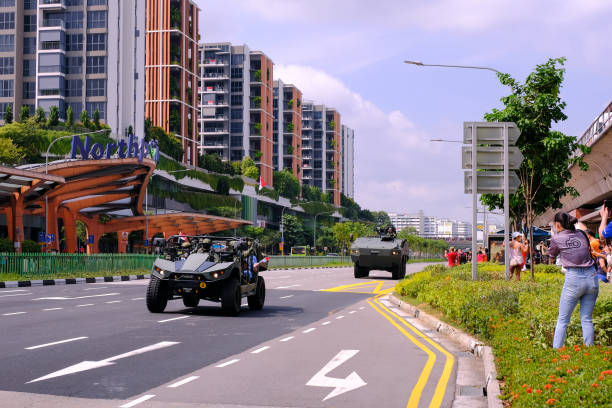 Singapore Mobile Column military parade travelling through Yishun Northpoint City on National Day Singapore National Day Aug09 2020. The Mobile Column military parade travelling through Yishun heartlands, past Northpoint City, as covid-19 situation improved. Spectators taking photos from sidewalks ndp stock pictures, royalty-free photos & images