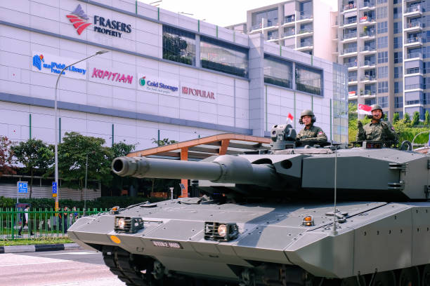 Singapore Mobile Column military parade travelling through Yishun Northpoint City on National Day Singapore Aug09 2020 Armoured vehicle passing in front of Northpoint City, Yishun, during The Mobile Column military parade on National Day; soldiers waving flags at spectators. Selective focus ndp stock pictures, royalty-free photos & images