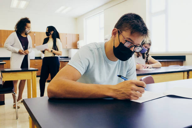 istock High School Teacher and Students In Classroom Wearing Protective Face Mask 1264961218