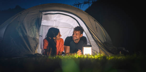 istock Contented Young Campers Side by Side on Tent Porch at Dusk 1264967751
