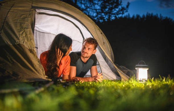 istock Contented Young Campers Side by Side on Tent Porch at Dusk 1264967754