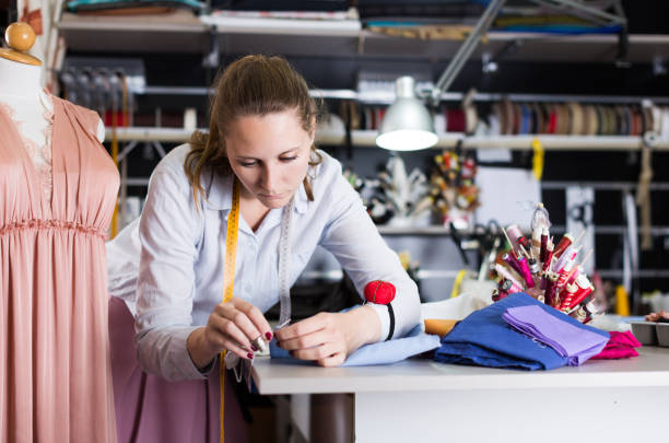 istock Woman worker sew up  textile  material at sewing workshop 1264968918