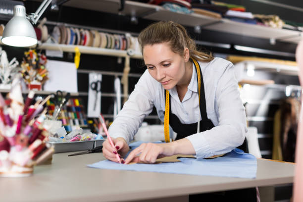 istock Smiling woman tailor working with marker for modeling clothes 1264968926