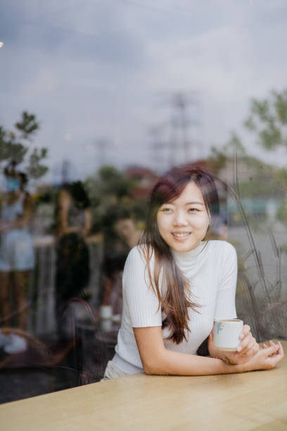 istock Young asian woman having a coffee break in a cafe 1264970137