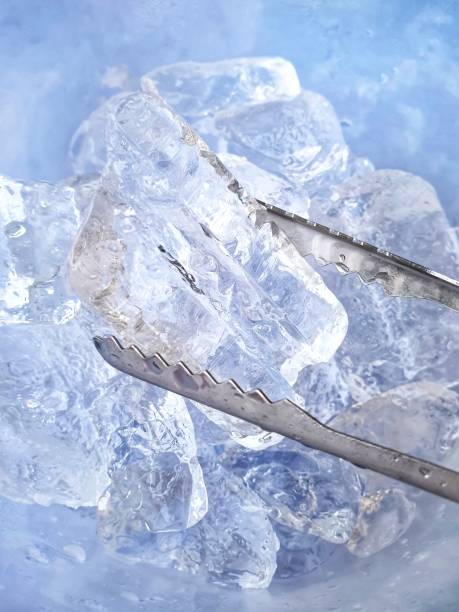 istock wallpaper Ice cubes with stainless tongs. 1264970393