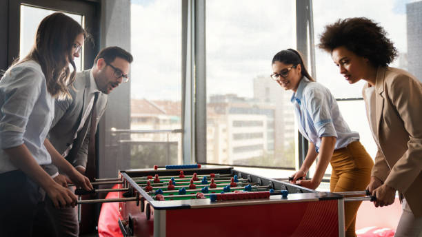 istock Colleagues playing table football in the break. 1264970428