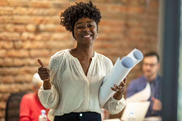 istock Black female architect smiling in busy office. 1264972506