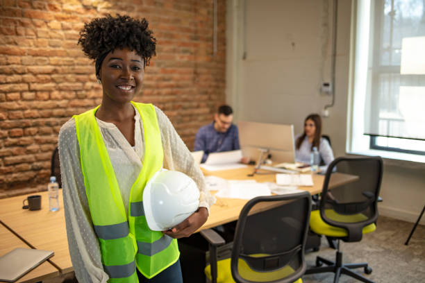 istock Young architect holding hardhat and blue print. 1264972681