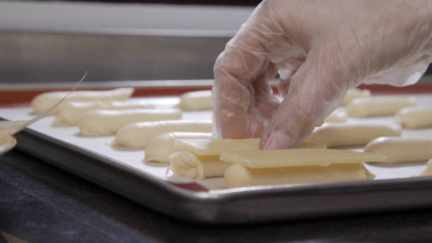 istock Confectioner decorating eclair with white milk chocolate. Chef cooking eclair. Professional pastry 1264974564