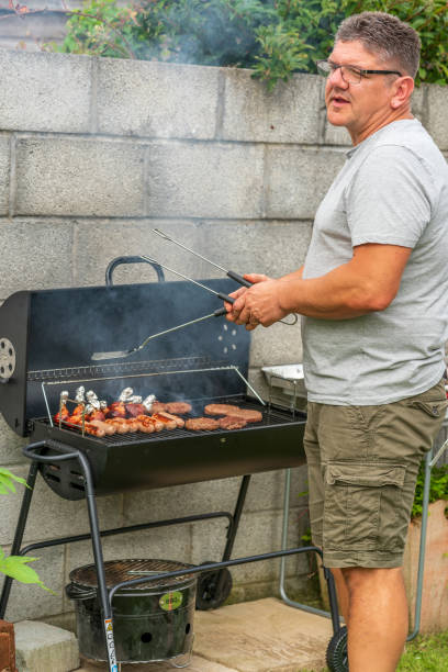 istock Mature man cooking on backyard BBQ 1264975874
