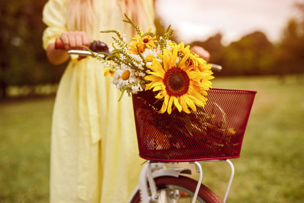 istock Crop woman pushing bicycle with flowers 1264976326