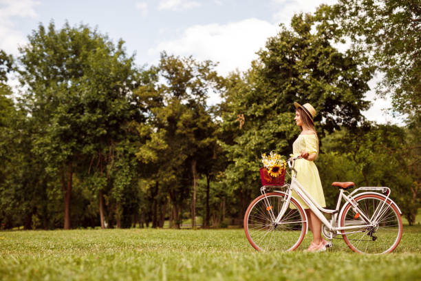 istock Young woman with bicycle in meadow 1264976335
