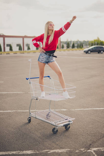 istock Confident young hipster riding shopping trolley 1264976355