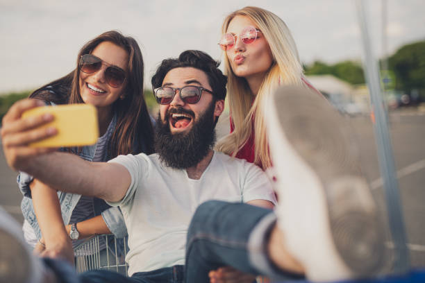 istock Bearded man taking selfie with women during shopping 1264976371