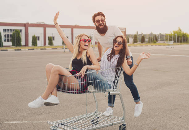 istock Delighted young people riding shopping trolley 1264976391