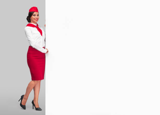 istock Cheerful ethnic stewardess with large blank banner 1264976491