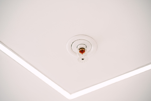 Automatic ceiling fire sprinkler system on white ceiling. High quality photo