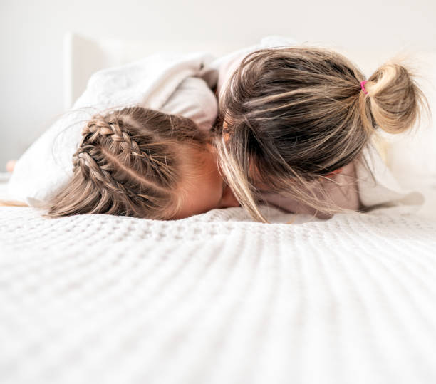 istock Mother playing with the children on the bed 1264978032
