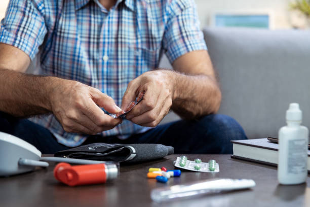 istock Man taking a pill out of a blister pack 1264980107