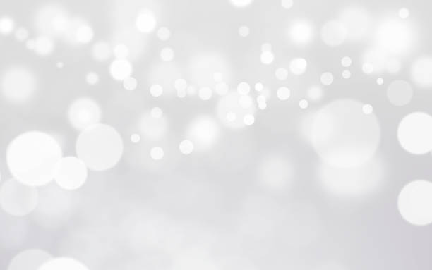 istock White bokeh, snowfall, defocus glitter blur on gray background. illustration. 1264980389