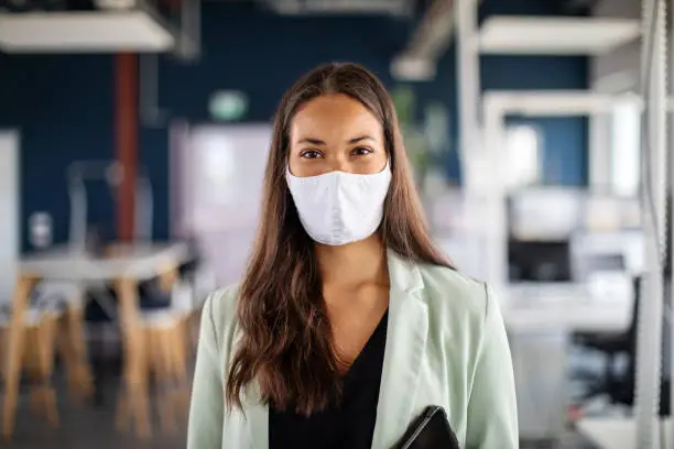 Photo of Portrait of a businesswoman with face mask in office