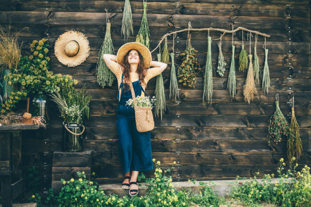 Attractive girl wearing straw hat and blue denim dungarees relaxing. stock photo