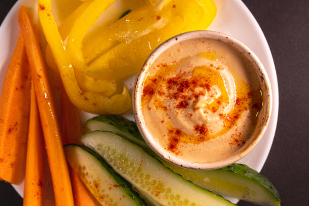 istock Hummus dip and vegetables on a plate, top view with copy space. 1264982585