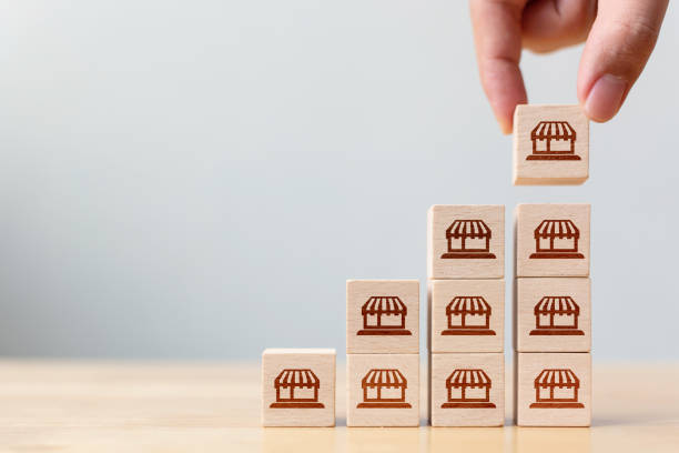 istock Franchise business marketing system concept. Structure service store network strategy. Hand putting wooden block on top with icon store 1264982698