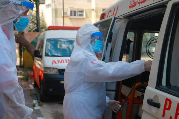Paramedic Woman with medical mask. sprayes disinfectant in a their Ambulance Qalqilya, Palestinian Territories, Palestine, August 10, 2020. Paramedic Woman with medical mask. sprayes disinfectant in a their Ambulance to prevent the spread of coronavirus (Covid-19), after a virus outbreak in the city west bank photos stock pictures, royalty-free photos & images