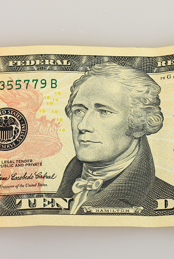 Ten American Dollars as banknote on table.