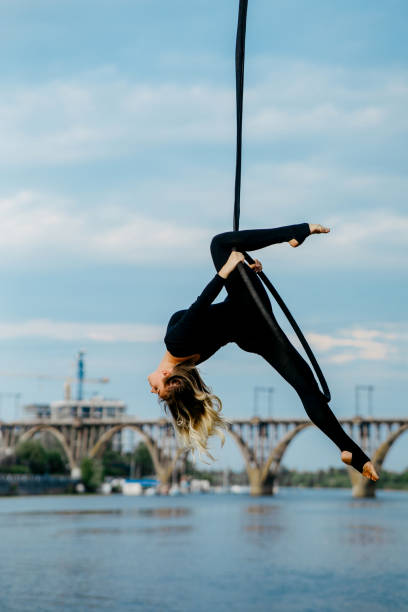 istock Woman aerialist performs acrobatic elements in hanging aerial hoop. 1264984812