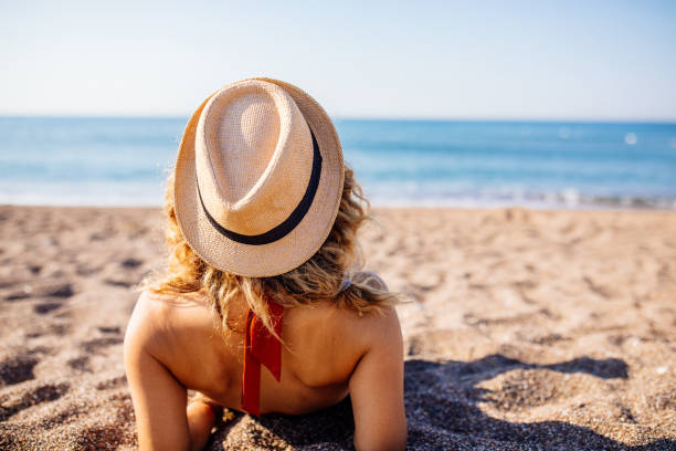 istock Woman Relaxing and Sunbathing at Beach 1264985419